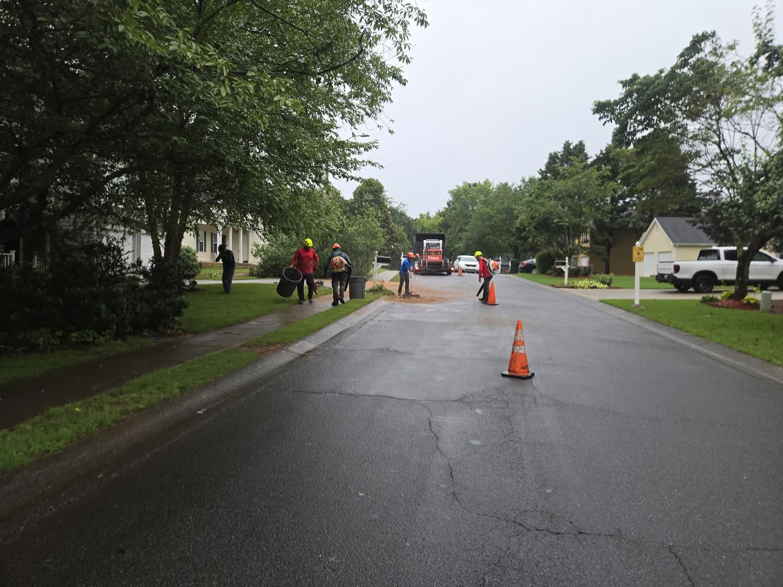 Tree service crew sweeping and blowing the street clean after a removal in Acworth GA, June 2026