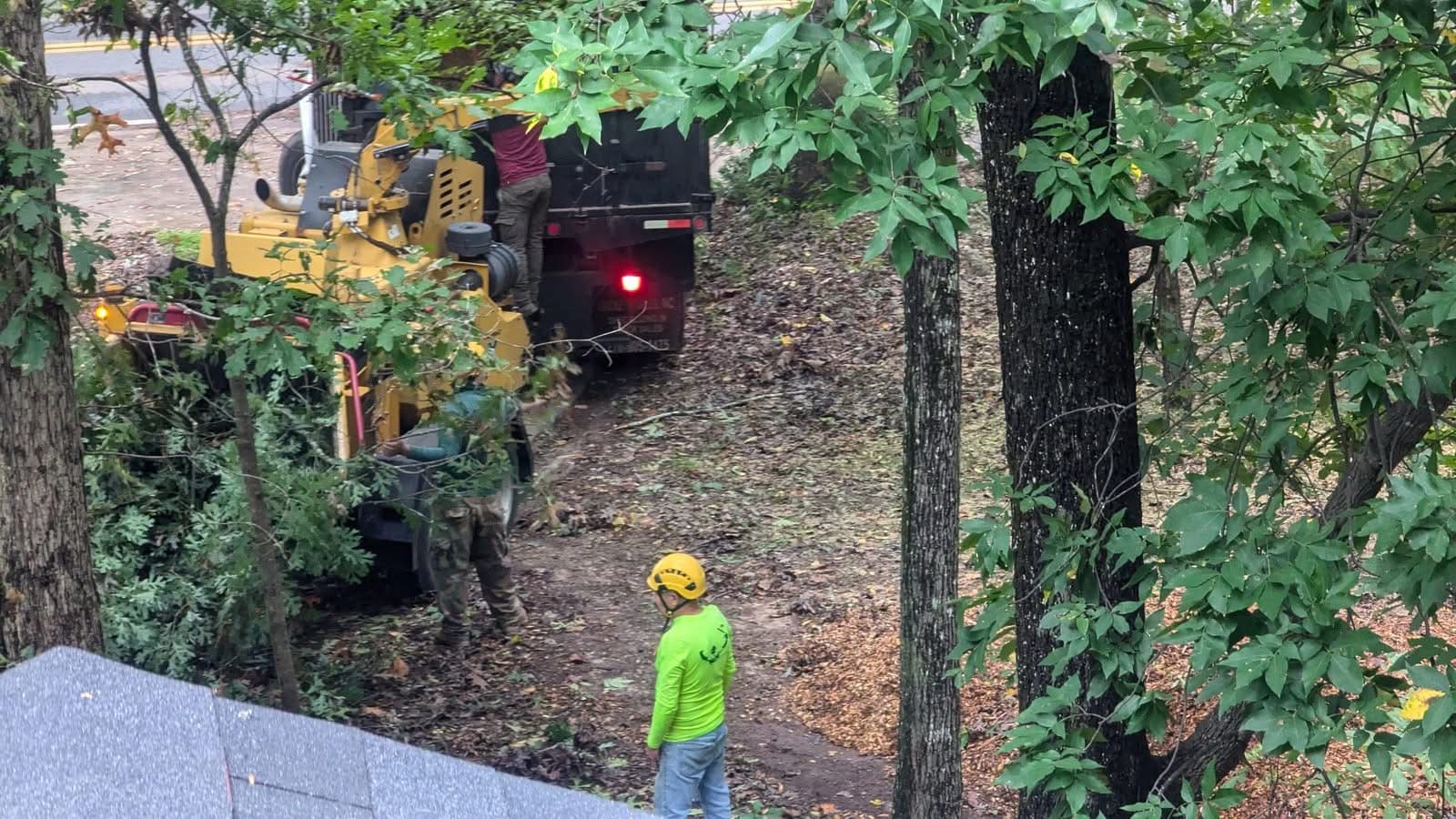 Chipper and chipper truck at the street as the crew feeds storm debris from an Alpharetta GA tree removal, September 2024