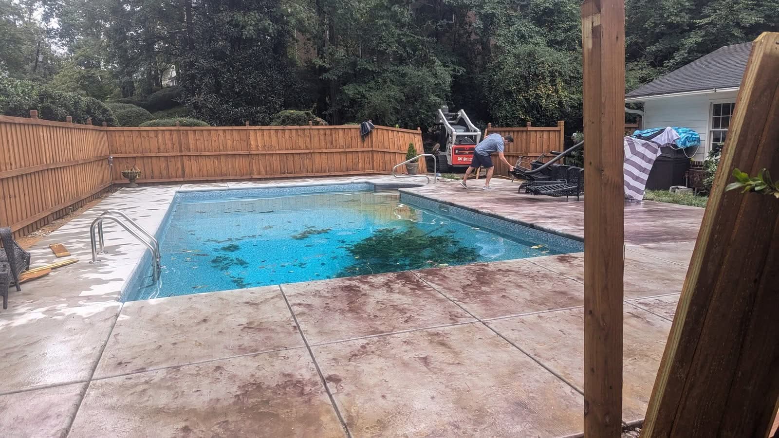 Cleared pool deck after storm tree removal with fence opened for equipment access in Atlanta GA, September 2024