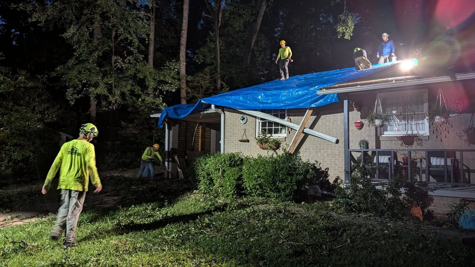 Crew tarping a damaged roof at night after emergency tree removal in Decatur GA, July 2024