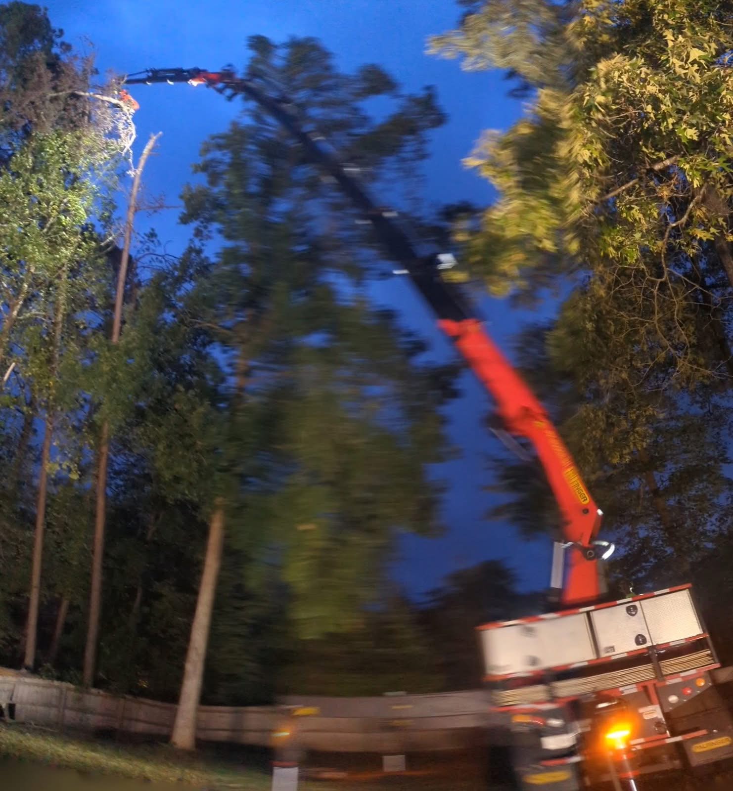Grapple saw crane reaching over trees during a night storm removal in Kennesaw GA, September 2024
